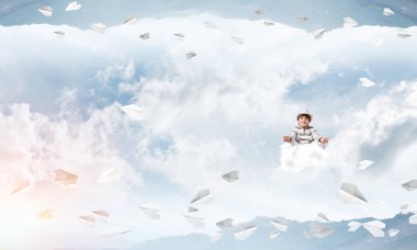 Genç küçük çocuk gözleri koruma kapalı ve seyir bulut uçan kağıt uçaklar arasında ve doğa dünyalar arasında üzerinde meditasyon sırasında konsantre.