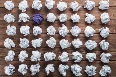 Fikir olarak ahşap masanın üzerine buruşmuş beyaz kağıt parçası.