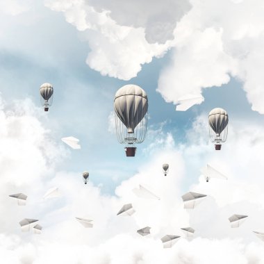 Renkli aerostats kağıt uçaklar arasında ve mavi bulutlu gökyüzü üzerinde uçan. 3D render.