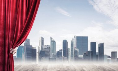 İnsan eli modern cityscape ve bulutlu gökyüzü kırmızı kadife perde açılır