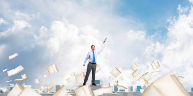 Clear sky kitaplarla arka plan üzerinde uçan arasında duran el kitabı ile uydurarak iş adamı. Karışık teknik.