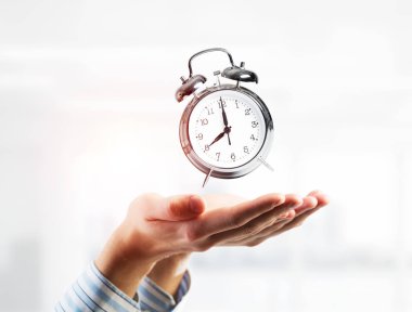 Çalar saat elinde tutan işadamı kapatın. Karışık teknik