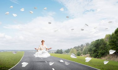 Genç adam gözleri koruma kapalı ve seyir ile güzel ve nefes kesici manzara arka plan üzerinde bulut yukarıda yolun üzerinde meditasyon sırasında konsantre.