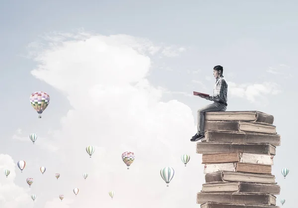 Joven Sorprendido Sentado Montón Libros Con Uno Las Manos —  Fotos de Stock