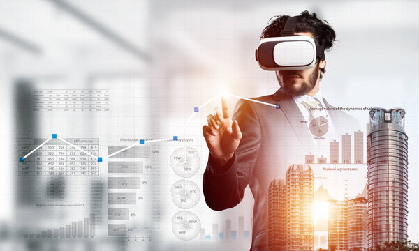 Молодой привлекательный бизнесмен в виртуальном шлеме на фоне городского пейзажа
