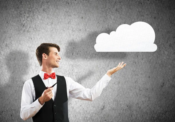 スマート カジュアル パイプを喫煙と提示の背景に灰色の暗い壁に立っている間紙雲に自信を持って 若いビジネスマンの水平ショット — ストック写真