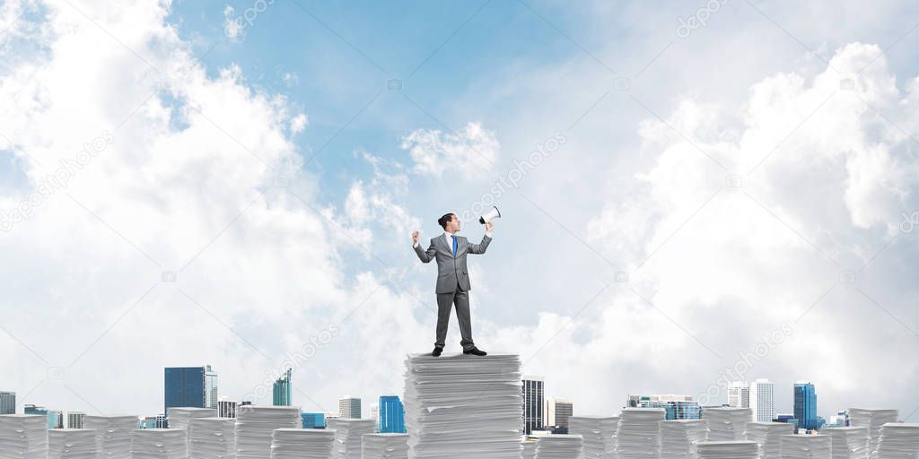 Businessman standing with megaphone.