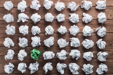 Fikir olarak ahşap masanın üzerine buruşmuş beyaz kağıt parçası.