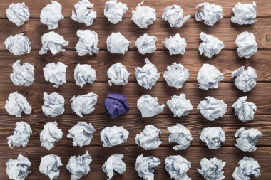 Fikir olarak ahşap masanın üzerine buruşmuş beyaz kağıt parçası.