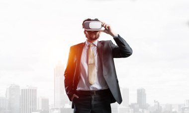 Genç yakışıklı iş adamı cityscape arka plan karşı sanal kask