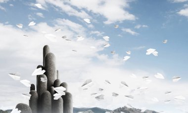 Açık havada, arka planda güzel manzarası olan uçan kağıt uçaklar arasında yer alan yüksek ve büyük taş sütunların resmi. Duvar kağıdı, telif alanı olan arkaplan.
