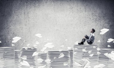 Düşünceli işadamı uzakta otururken kağıt uçan arasında seyir gri arka plan ile uçak. Karışık teknik.