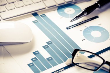 Klavye fareli iş yeri ve grafik ve diyagramlı kağıtlar