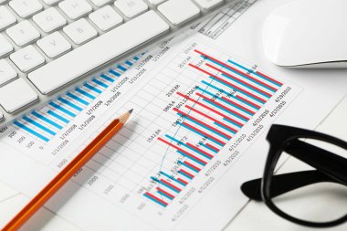 Klavye fareli iş yeri ve grafik ve diyagramlı kağıtlar