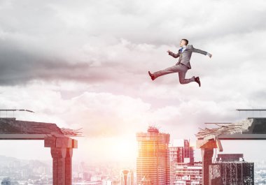 Zorlukların üstesinden sembolü olarak beton köprü boşluğu üstünden atlayarak iş adamı. Güneş ışığı ve cityscape arka plan üzerinde. 3D render.