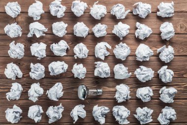 Akkor ampul ve buruşuk beyaz kağıt topları kahverengi ahşap tablo