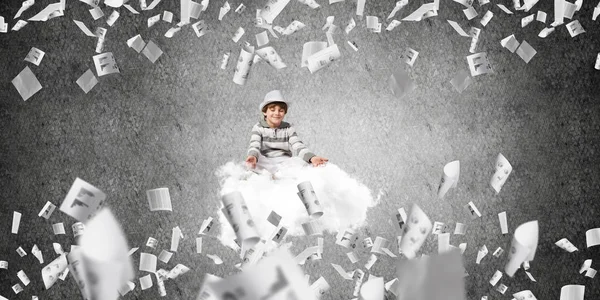 Genç küçük çocuk gözleri koruma kapalı ve seyir üzerinde uçan bulut ile gri karanlık duvar kağıtları arka plan üzerinde uçan arasında meditasyon sırasında konsantre.