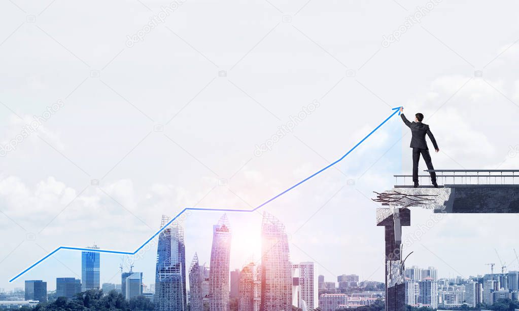 Businessman in suit drawing graphs on modern statistical media interface while standing on broken bridge with cityscape and sunlight on background. 3D rendering.