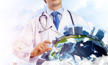 Genç ama beyaz steril giysi ve dünya küre ile bulutlu gökyüzü arka plan üzerinde büyüteç aracılığıyla keşfetmek ve boynunda steteskop profesyonel adam doktor. Tıp sektöründe kavramı. Nasa tarafından döşenmiş bu görüntü unsurları