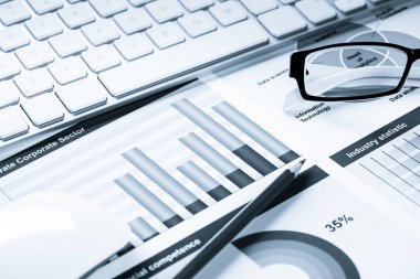 Klavye fareli iş yeri ve grafik ve diyagramlı kağıtlar