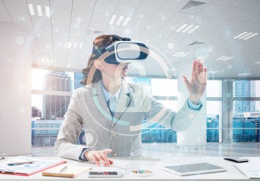 Güzel ve genç iş kadını kıyafetli dijital güvenlik arayüzü office içinde dururken ile sanal gerçeklik kulaklık kullanarak yatay çekim.