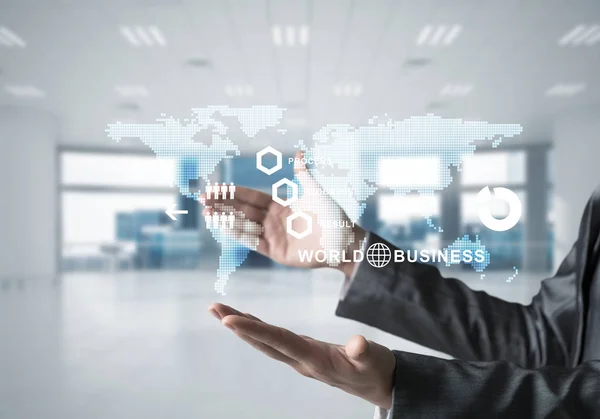 Business woman in suit with media interface and interactive world map in her hands. Office view on background. Mixed media.