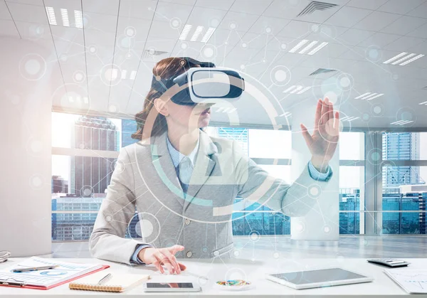 Güzel ve genç iş kadını kıyafetli dijital güvenlik arayüzü office içinde dururken ile sanal gerçeklik kulaklık kullanarak yatay çekim.