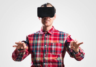 Ekose desenli gömlek gri arka plan karşı sanal kask giymiş genç adam