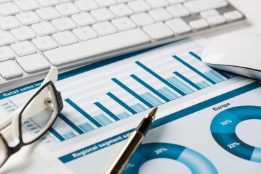 Klavye fareli iş yeri ve grafik ve diyagramlı kağıtlar