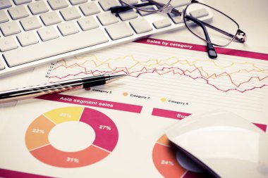 Klavye gözlüklü ve mali belgeleri masada olan iş yeri