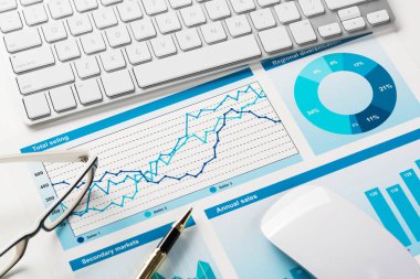Klavye fareli iş yeri ve grafik ve diyagramlı kağıtlar