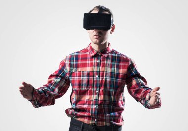 Ekose desenli gömlek gri arka plan karşı sanal kask giymiş genç adam