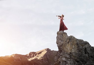 Keman ayakta rock üst kısmında oynayan genç çekici kız