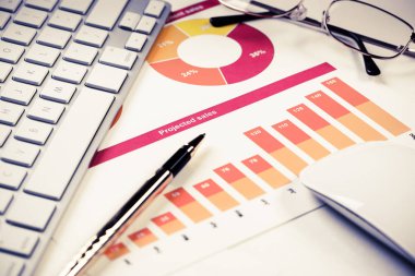 Klavye gözlüklü ve mali belgeleri masada olan iş yeri