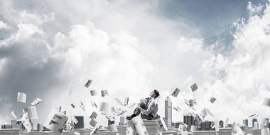 İş adamı uzak belgeler kağıtları Clear sky ile arka plan üzerinde uçan arasında yığını üzerinde otururken arıyorum. Karışık teknik.