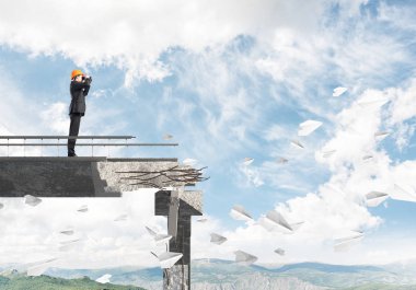 Genç takım elbiseli mühendis ve dürbün ile gökyüzü arka plan üzerinde kırık köprüde kağıt uçak uçan arasında duran seyir kask. 3D render.