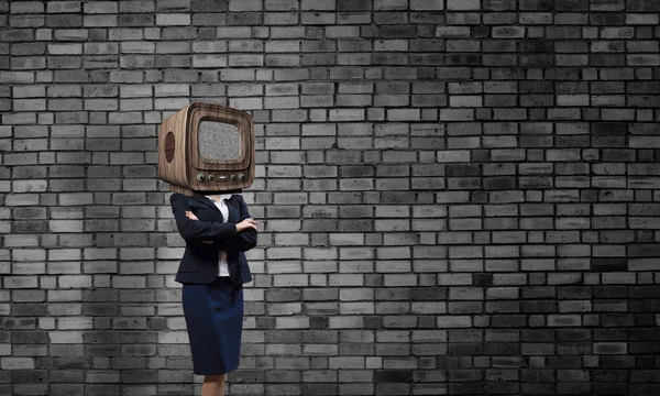 商业妇女与老电视 而不是头部保持双臂交叉 而站在空房间灰色的黑暗的墙壁背景 — 图库照片