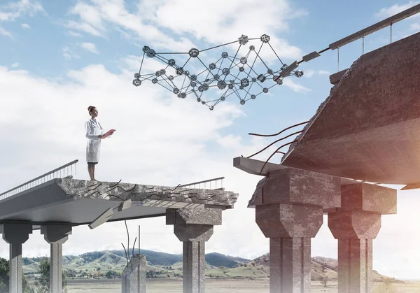 Medical industry employee in white medical uniform examining social network structure while standing at the end of broken bridge. Medical industry concept. Landscape view on background