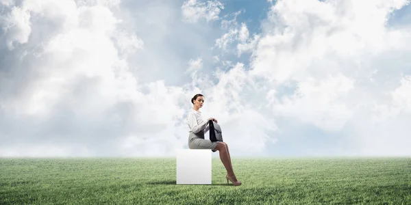 Elegante Geschäftsfrau Mit Koffer Der Hand Sitzt Auf White Cube — Stockfoto