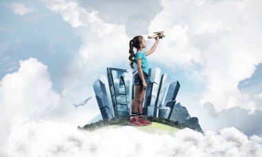 Şehrin yüzen adasında eski model uçaklarla oynayan tatlı bir kız.