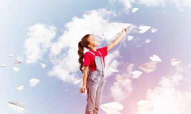 Kağıt Uçak ile oynarken gökyüzü arka plan karşı küçük şirin kız