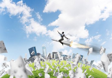 Kağıtları cityscape ve mavi gökyüzü ile arka plan üzerinde uçan arasında roket üzerinde uçan takım elbiseli genç işadamı kavramsal görüntü.
