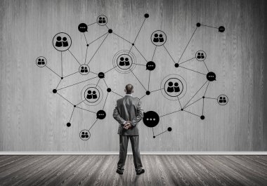 Arkadan görünüşü çizilmiş sosyal bağlantı kavramı ile duvara bakarak işadamı