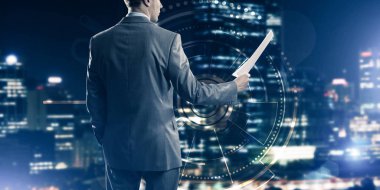 Sanal panel arayüzüne karşı iş adamının arka görünümü belgeleri elinde tutuyor