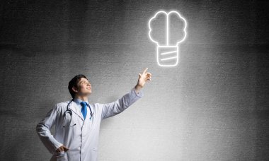 Arka planda gri koyu duvara karşı dururken havada parlayan vida sembolü ile müdahale beyaz tıbbi takım profesyonel tıp endüstrisi çalışanı.