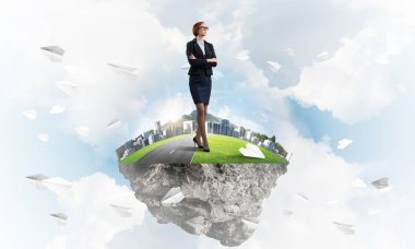 Mavi gök yeşil yüzen ada üzerinde duran zarif emin iş kadını