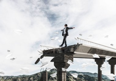 Gizli tehditler ve risklerin simgesi olarak beton köprüde uçan kağıt uçakların arasında gözü kapalı yürüyen bir işadamı. Arka planda gökyüzü ve doğa manzarası. 3B görüntüleme.