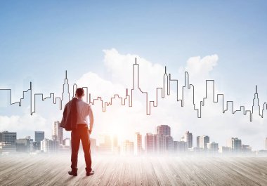 İşadamı arkasını dönüp modern iş merkezinin siluetine bakıyor.