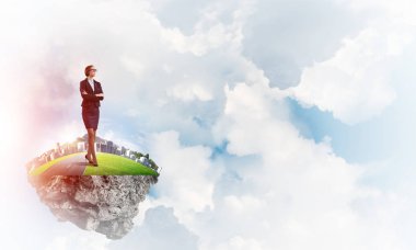 Mavi gök yeşil yüzen ada üzerinde duran zarif emin iş kadını