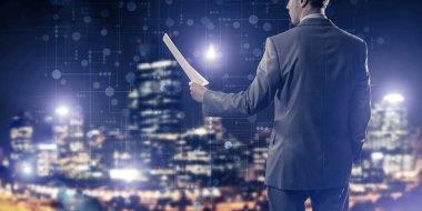 İş adamı elinde kontratla ya da elinde raporuyla ayakta duruyor.